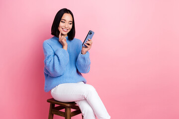 Photo of adorable nice woman straight hairdo dressed knit pullover look at smartphone finger on...