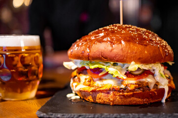 very big burger with a beer in pub