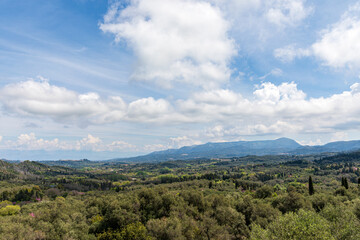 Naklejka premium A beautiful landscape of the island of Corfu in the Ionian Sea in Greece. Mountains with plenty of green vegetation. Thick clouds over the island. 