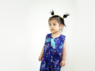 Little asian girl in a blue dress in studio on a white background. Image of Asian child posing on white background. Portrait of cute asian child girl tied her hair into three corks. 