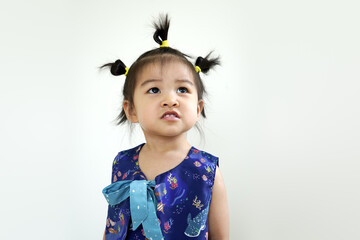 Little asian girl in a blue dress in studio on a white background. Image of Asian child posing on white background. Portrait of cute asian child girl tied her hair into three corks. 