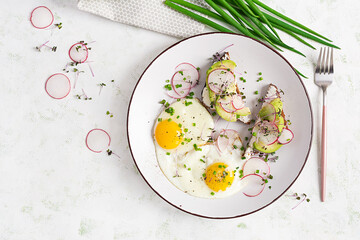 Fried eggs and sandwiches with avocado and radish  for healthy breakfast. Top view, flat lay