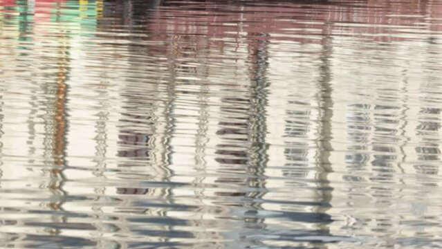 ripples on water with reflections of houses