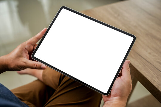 A businessman holds a mockup. iPad digital tablet with blank screen Mockup replaces your design mockup in the office.
