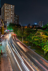 Fototapeta premium Busy traffic during sunset and night, colorful perspective of Ho Chi Minh city with numerous hotel, bar and shop sign boards, crowded with people, motorbikes