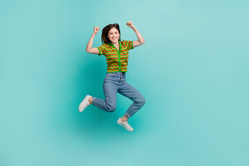 Fototapeta na wymiar Full length photo of cute lucky lady wear striped cardigan jumping high rising fists isolated turquoise color background