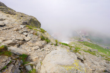 romanian countryside scenery on a foggy day. mountainous nature landscape with steep rocky hills. summer vacations in fagaras
