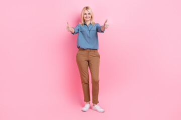 Full length photo of pretty confident woman wear grey shirt showing two thumbs up isolated pink color background
