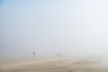 Fog on Baltic sea coastline at spring. Moody weather, mist. Cyclist riding in mist