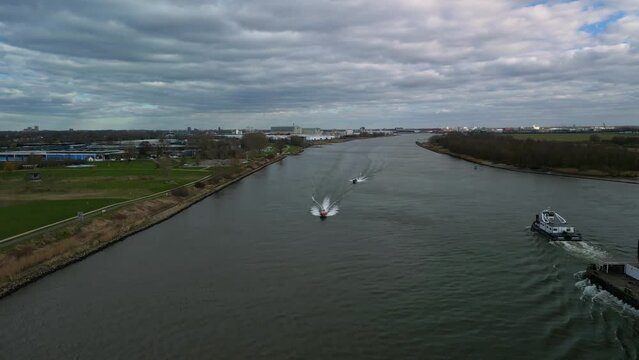 Aerial view of boats and industrial ships navigating through the inland canal of Zwijndrecht.