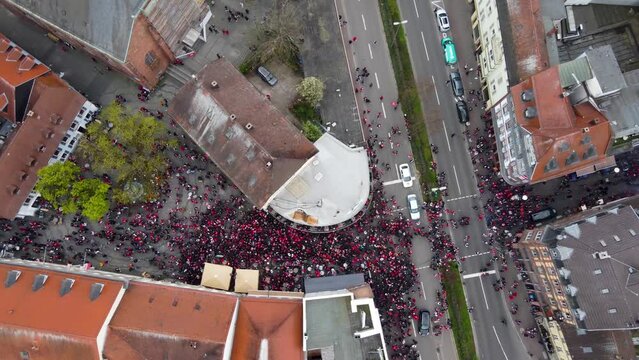 Birds eye rotating Aerial view : Audience and fans of FCK Football Club gathering at the Bars of old City ( Altstadt ) crowding by a street intersection to celebrate their Match win ( Victory )
