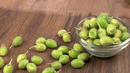 Fresh Green chickpeas on a branch, and in the pod, isolated on wooden background.