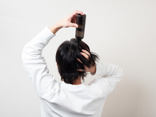 髪の毛に育毛剤を塗る男性の後ろ姿・スカルプケア	