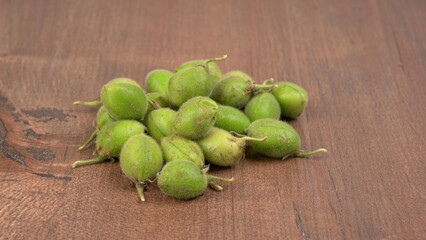 Fresh Green chickpeas on a branch, and in the pod, isolated on wooden background.