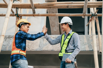 Construction workers, architects and engineers shake hands while working for teamwork and cooperation after completing an agreement in an office facility, successful cooperation concept.