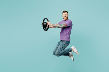 Full body side profile view surprised young man he wear purple t-shirt jump high hold steering...