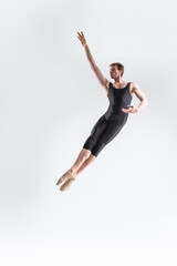 Fototapeta na wymiar Caucasian Ballet Dancer Young Caucasian Athletic Man in Black Suit Posing Flying Dancing in Studio On White