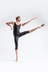Fototapeta na wymiar Professional Ballet Dancer Young Caucasian Athletic Man in Black Suit Posing Flying Dancing in Studio On White.
