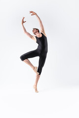 Obraz premium Professional Male Ballet Dancer Young Athletic Man in Black Suit Posing in Ballanced Stretching Dance Pose Studio On White.