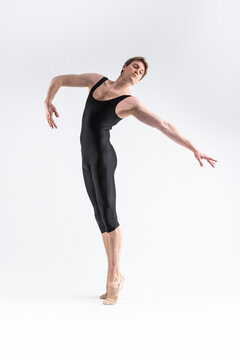 One Caucasian Ballet Dancer Young Athletic Man in Black Suit Posing in Studio On White. Vertical image