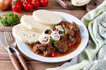 Traditional czech goulash with dumplings on table