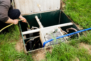 The man is cleaning septic. Maintenance autonomous sewerage service. Processing station biological...