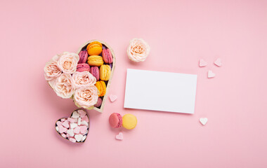 Cookies Macaroons in Gift Box, Rose Flowers and Candies on Pink Background. Holiday Presents Concept