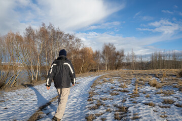 Man walking on snow-covered ground and melting hoar frost, Twizel, South Island