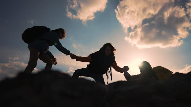 Helping hand in teamwork.Group of climbers daring climb to victory.People reach out to each other by hand providing help and support at every step of way.Power of teamwork.Together reach new heights