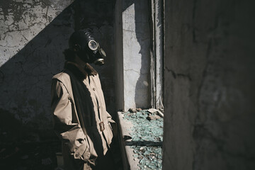 a person wearing a gas mask is standing in front of the window of a destroyed house
