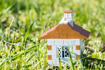 The concept of a brick reliable house with windows on green grass, a symbol of construction,...