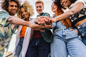 Obraz premium Multiracial friends holding hands together outdoors - Portrait of happy millennials - Teamwork unite and support together
