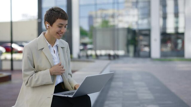 Online Meeting. Smiling Businesswoman is Sitting on the Bench and Working on the Laptop Having Video Conference. Distance Work. Cute Lady Boss Online. Man Using his Laptop While Sitting Outdoors