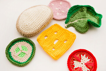 Handmade crochet sandwich with sausage, salad, cheese, cucumber and tomato. Healthy breakfast, kitchen toys for preschool children. Sensory cooking games at home, to develop kids imagination.