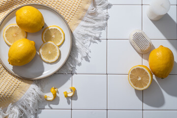 A dish of Lemon slices placed on a wool scarf decorated with candle and a scrub brush. Blank space...