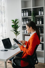 Business woman using tablet and laptop for doing math finance on an office desk, tax, report, accounting, statistics, and analytical research concept in office