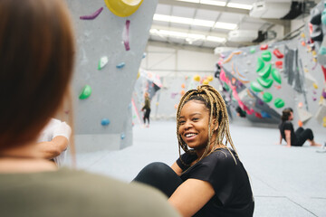 Multi-Cultural Group Of Friends Chatting By Climbing Wall In Indoor Activity Centre © Southworks