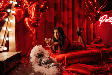 Portrait of smile sexy asian girl glam makeup in red lace lingerie lying on bed at valentines day