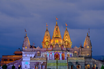 Obraz premium Night illuminated Shree Swaminarayan temple with dark blue cloud background.