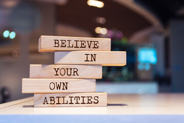 Wooden blocks with words 'Believe in your own abilities'. Inspirational motivational quote