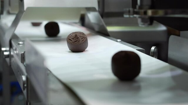 Conveyor belt with chocolates in close-up.
