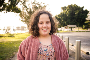 Close-up of a smiling girl walking along a footpath