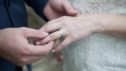 wedding rings. The groom puts the ring on the bride's finger, close-up of hands. Hands of the groom and bride