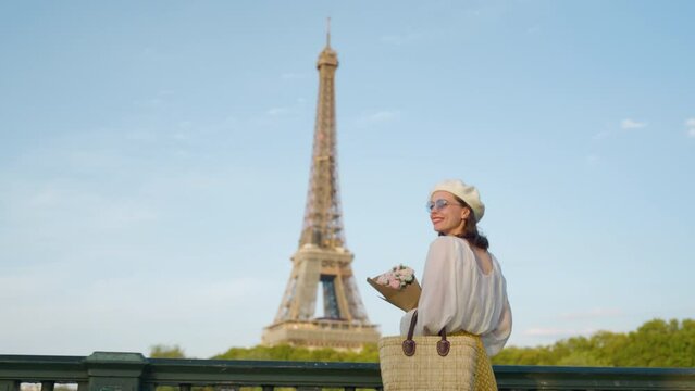 Attractive girl with flowers on the background of the Eiffel Tower