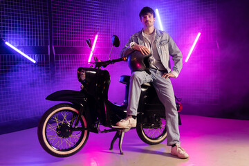 Fototapeta na wymiar 80s sytle young man on scooter with purple background