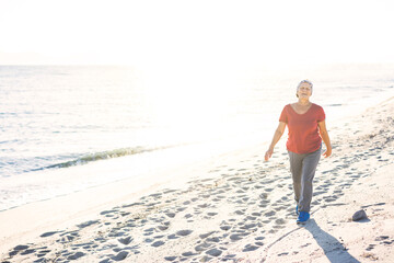 Senior woman exercising, walking at the beach