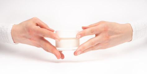 Mock-up of beautiful woman's hand holds round jar or container of cosmetic product cream or lotion on white isolated background. Concept of beauty, spa industry, skin care. Close-up, copy space