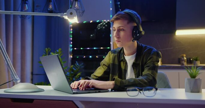 Handsome Caucasian Man Working On Laptop Computer While Sitting Behind Desk In Living Room. Freelancer Male Professional Writing An Important Email From Working From Home.