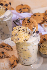 Edible raw cookie dough smoothie. Sweet loaded american raw cookie dough shake drink, with chocolate chips cookies, on beige background
