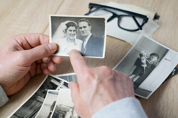 an elderly man looks through his old photographs of 1960-1965, the concept of nostalgia and...